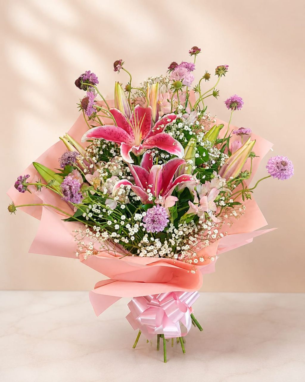 Buquê de lírios rosa com flores do campo